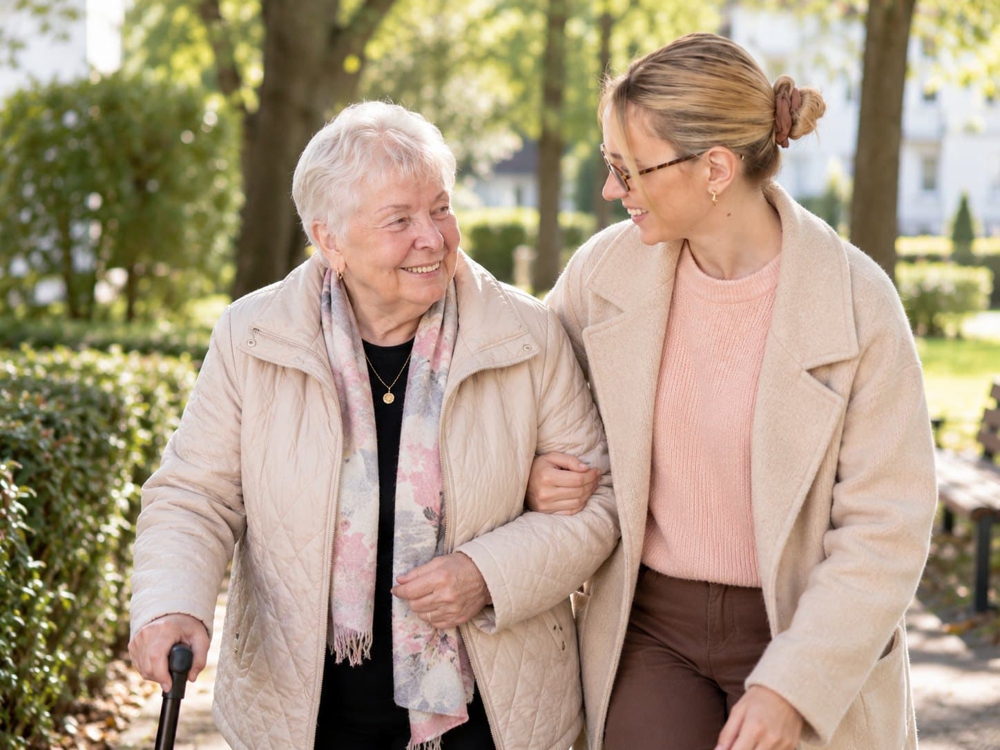 Betreuungskraft und Senior beim gemeinsamen Spaziergang im Park
